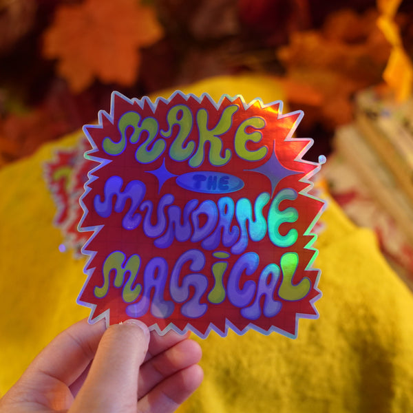 Colorful sticker with text held by a person against a blurred background