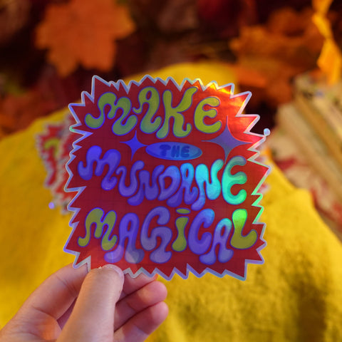 Colorful sticker with text held by a person against a blurred background